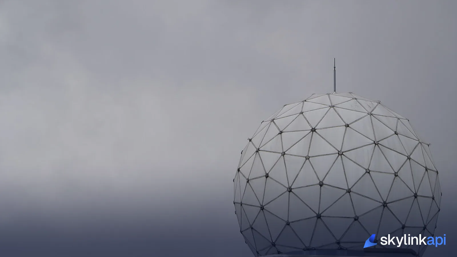 A radar dome against a grey sky