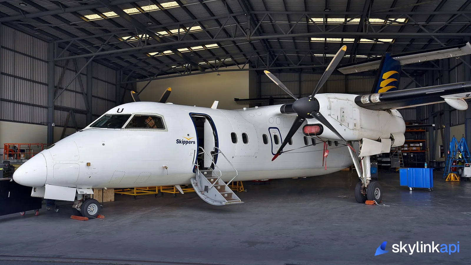 A regional turboprop inside a maintenance hangar — every airframe has a registration, hex code, and type