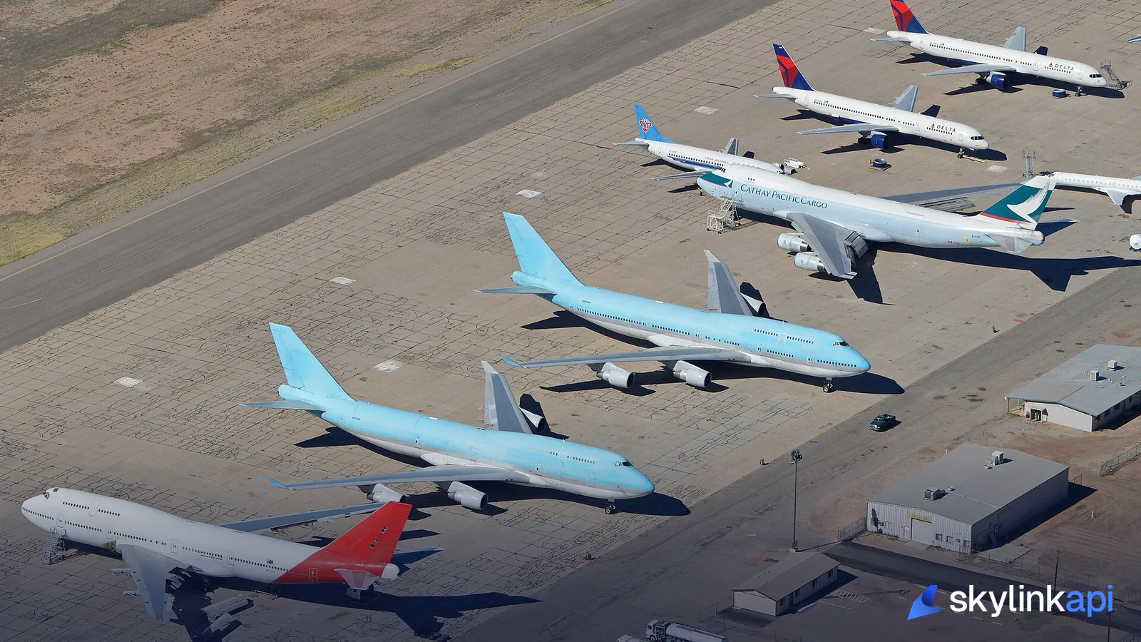 An aerial view of many different airliner types parked together
