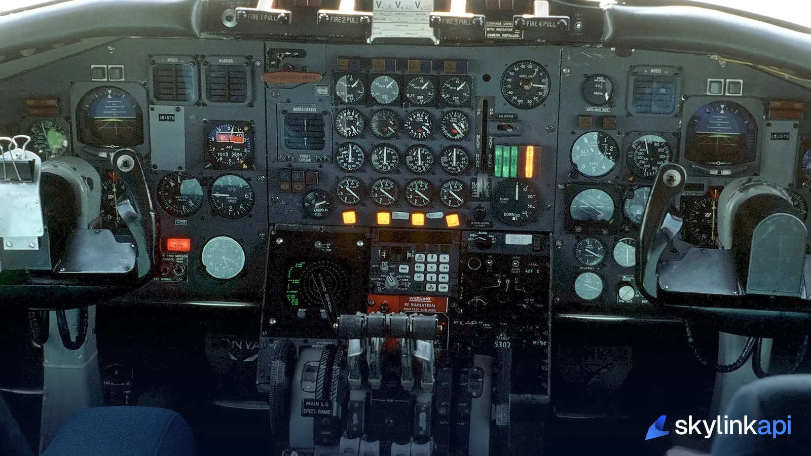 An airliner flight deck with the instrument panel lit