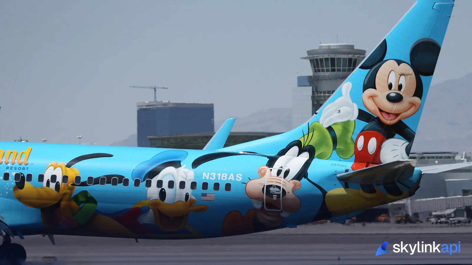 A Disney-liveried Boeing 737's tail fin — an airline's livery, codes, and callsign all identify the same carrier