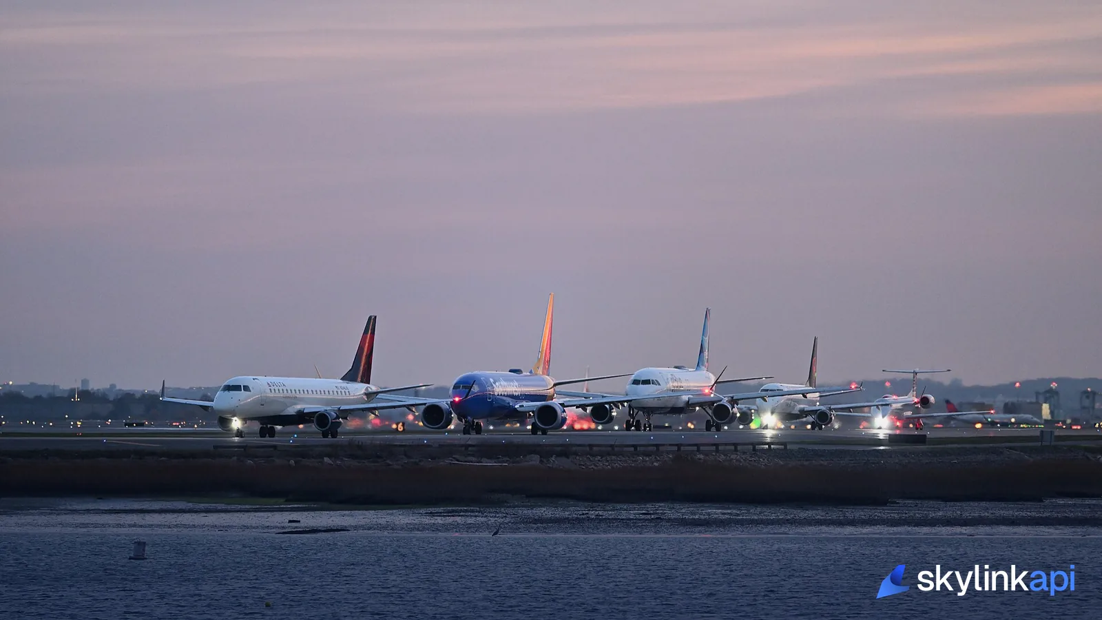 Airliners lined up nose-to-tail on a taxiway waiting to depart