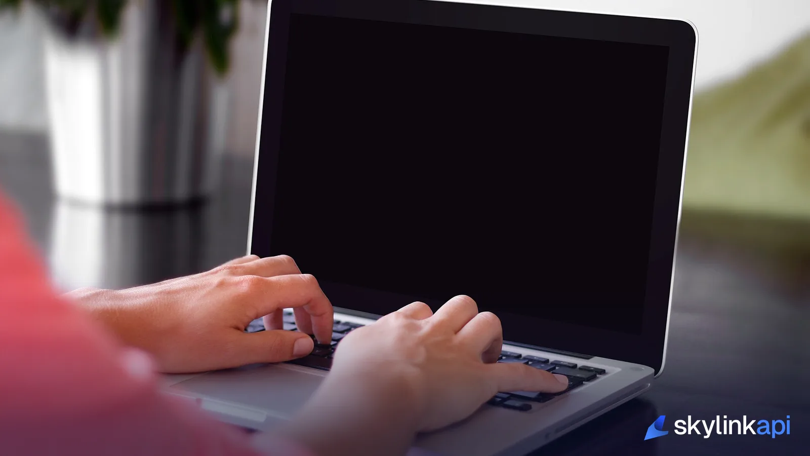 Hands typing on a laptop keyboard, building an automation workflow