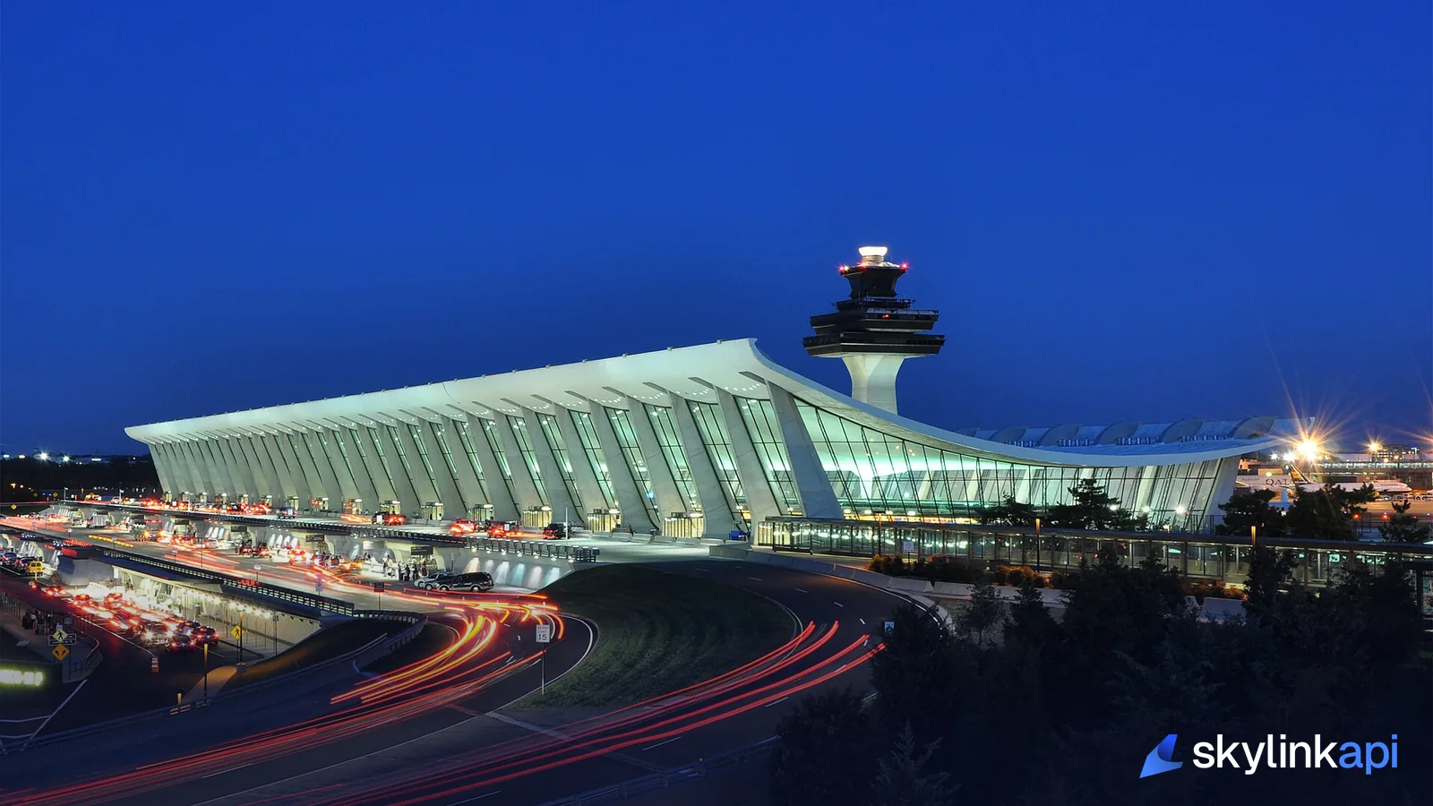 Washington Dulles airport terminal and control tower at dusk with car light trails