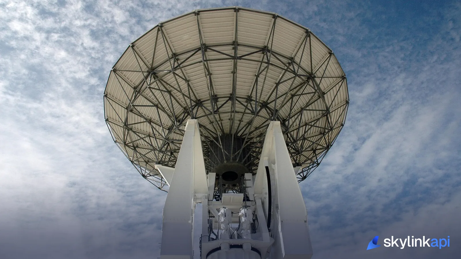 A parabolic receiving antenna against a cloudy sky
