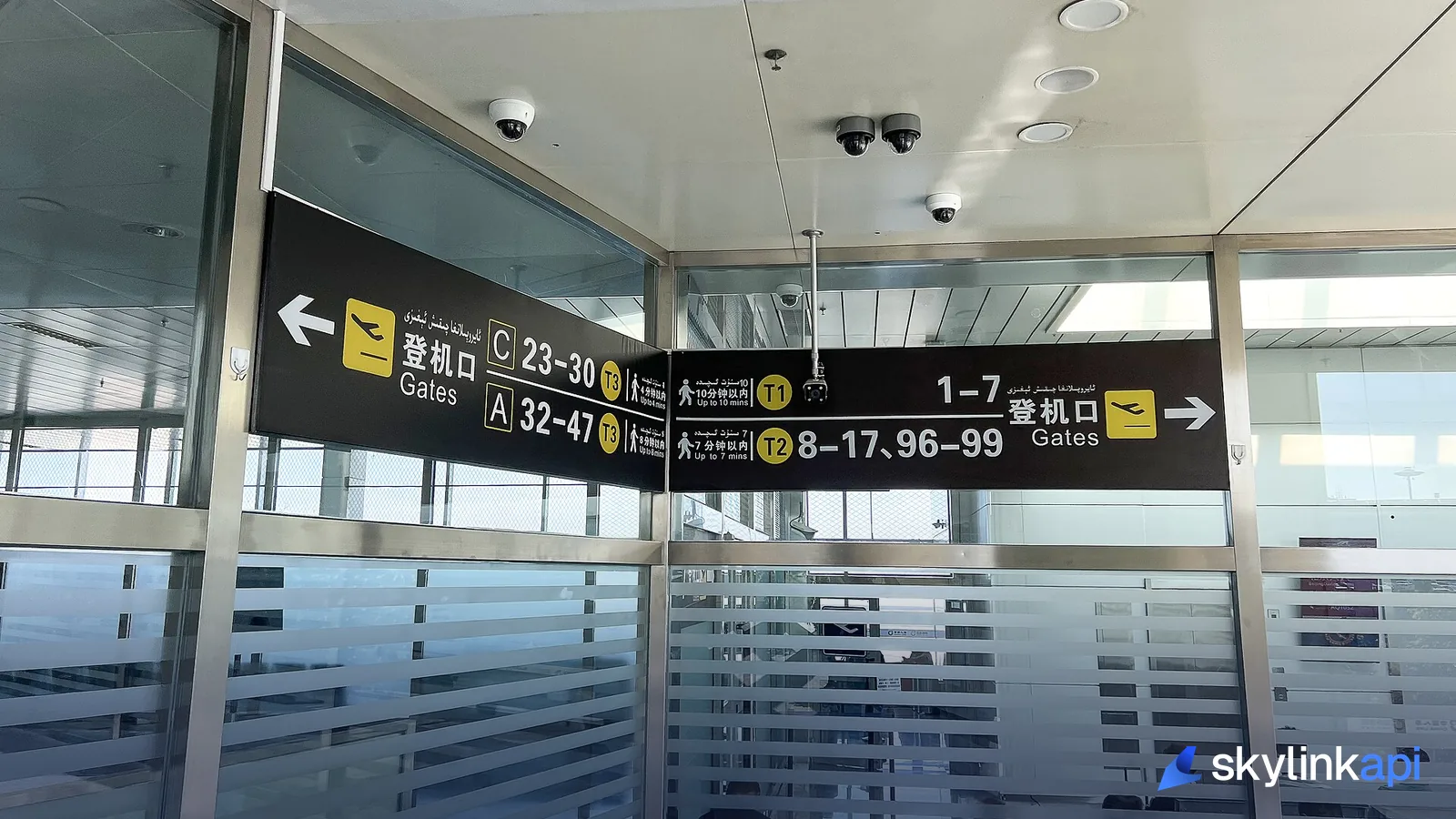 Multilingual airport gate-direction signage pointing passengers to numbered boarding gates