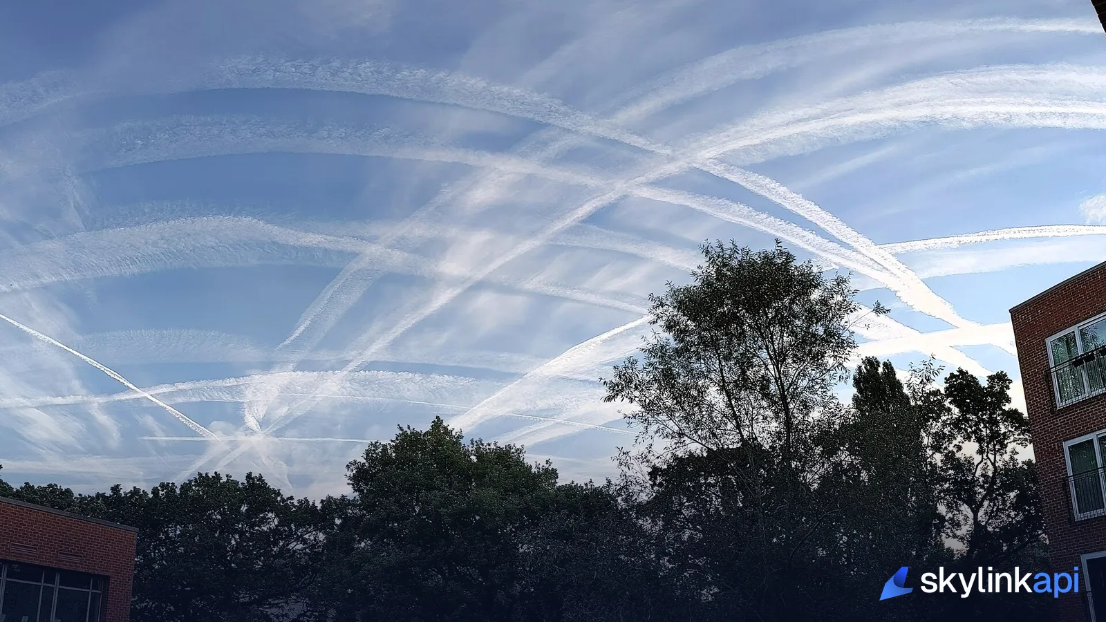 Criss-crossing contrails spreading across a blue sky