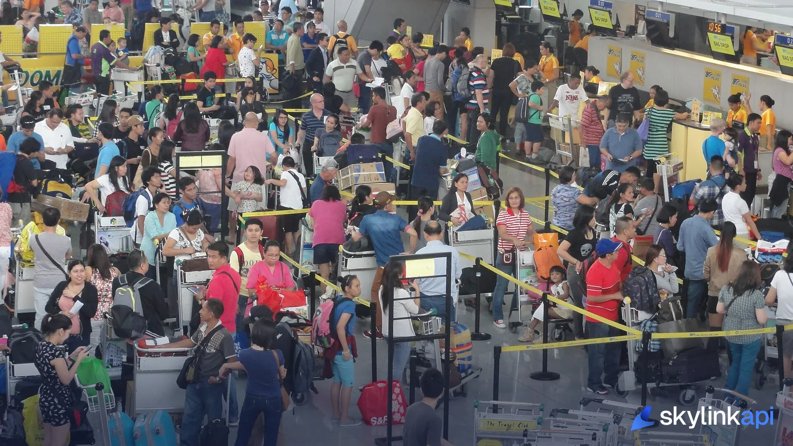 Passengers crowding the check-in hall at a busy airport terminal