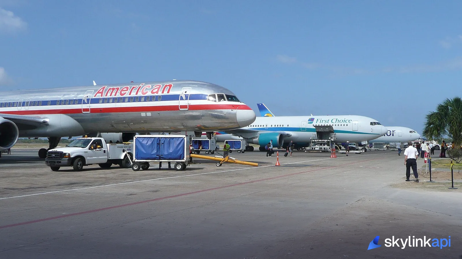 Ground crew working around a parked aircraft on the ramp