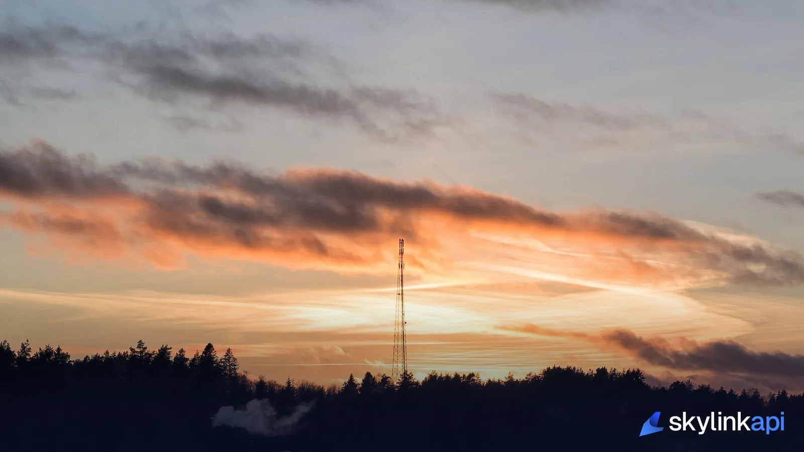 A radio antenna mast standing against the sky, like the ground receivers that pick up ADS-B broadcasts