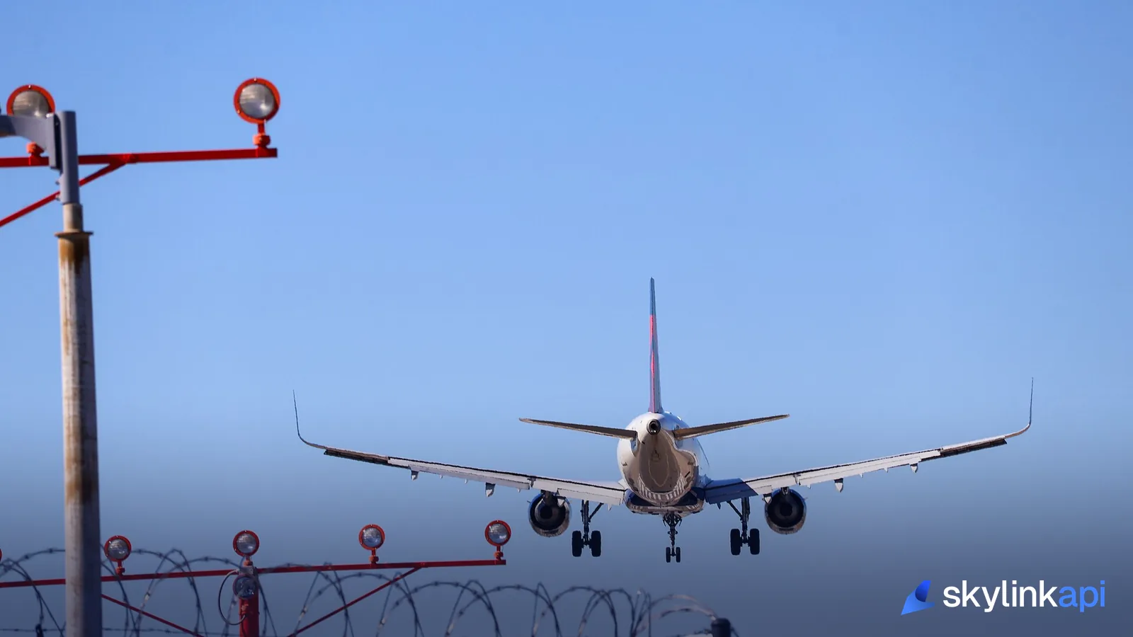 A jet on short final over the red approach lights, moments before touching down on the runway
