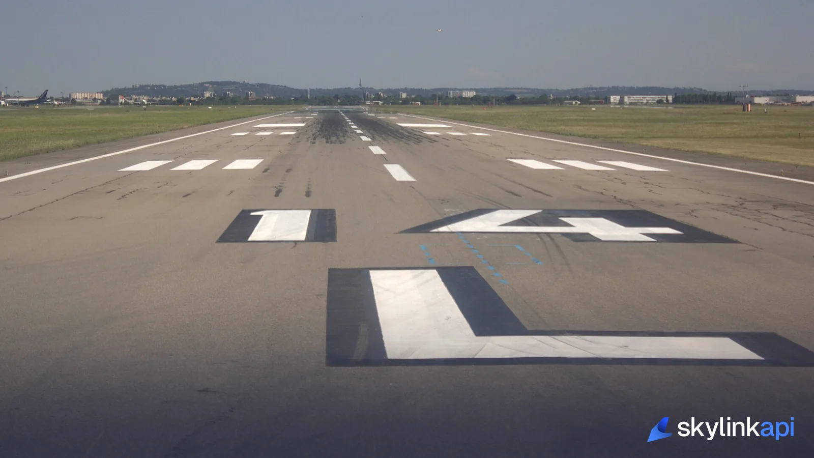 The "14 L" runway designation and touchdown-zone markings viewed from ground level down the runway