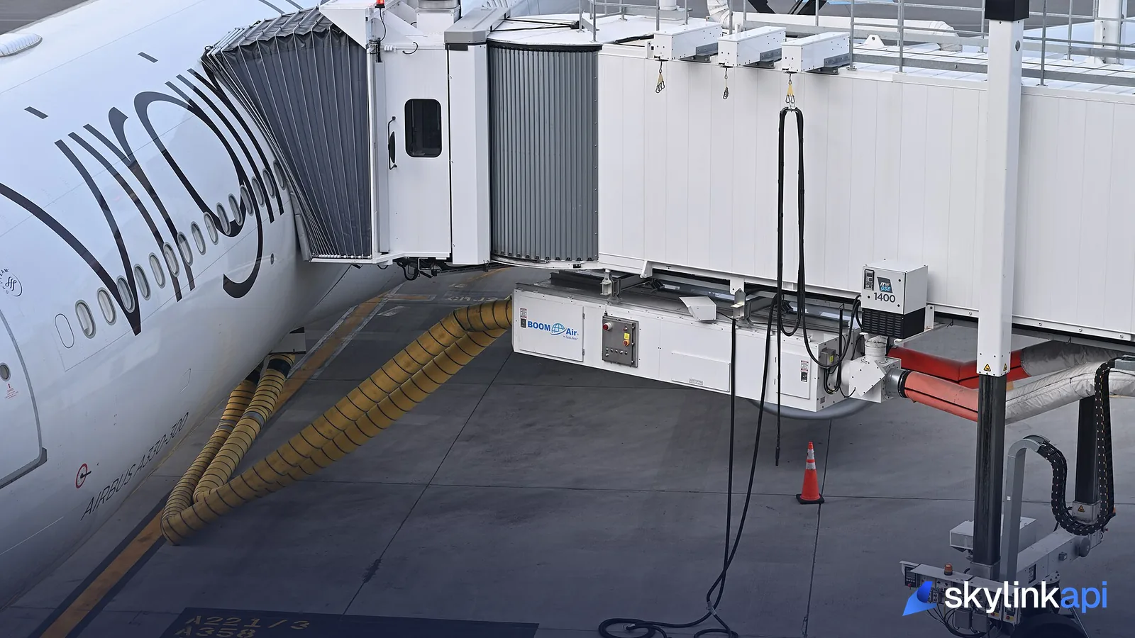 An Airbus A330 parked at a jet bridge, with ICAO aircraft type codes stencilled on the apron stand