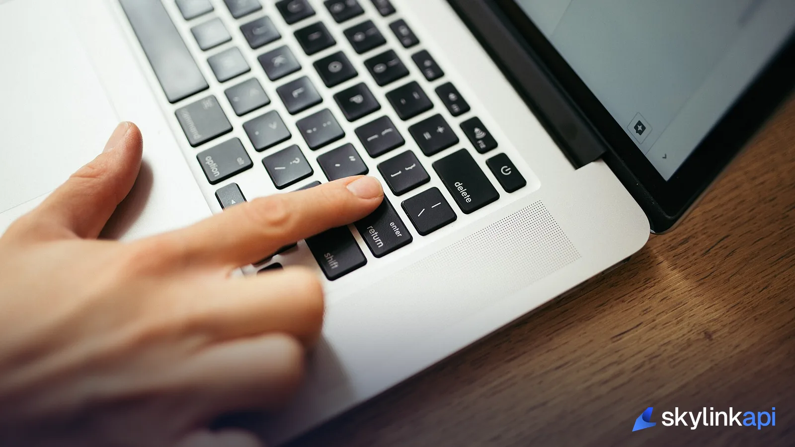 A hand pressing keys on a laptop keyboard