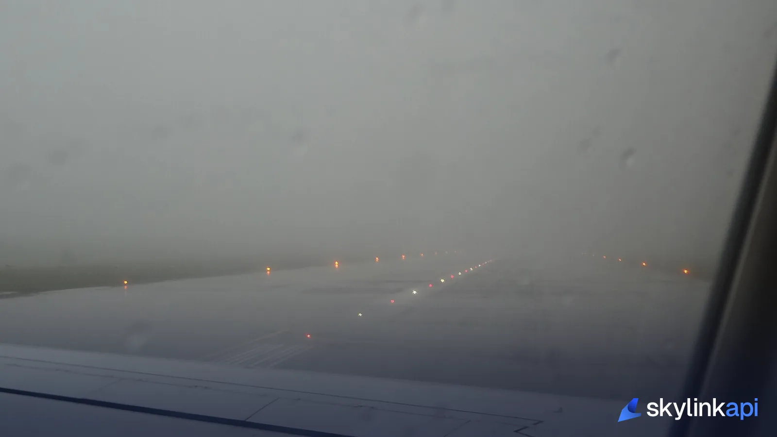 Runway lights fading into fog, seen from the flight deck