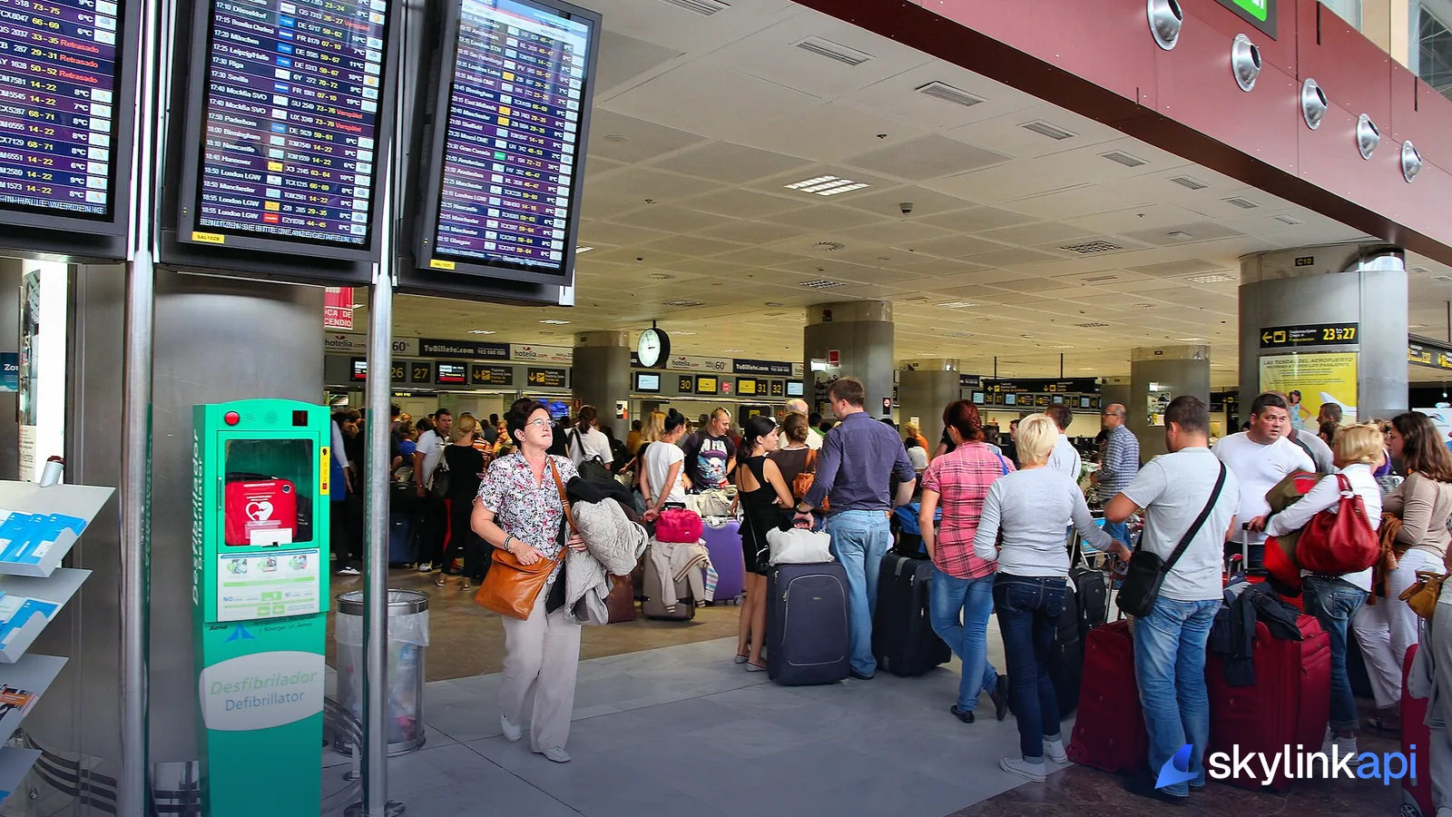 Passengers under the departure screens at Tenerife South Airport