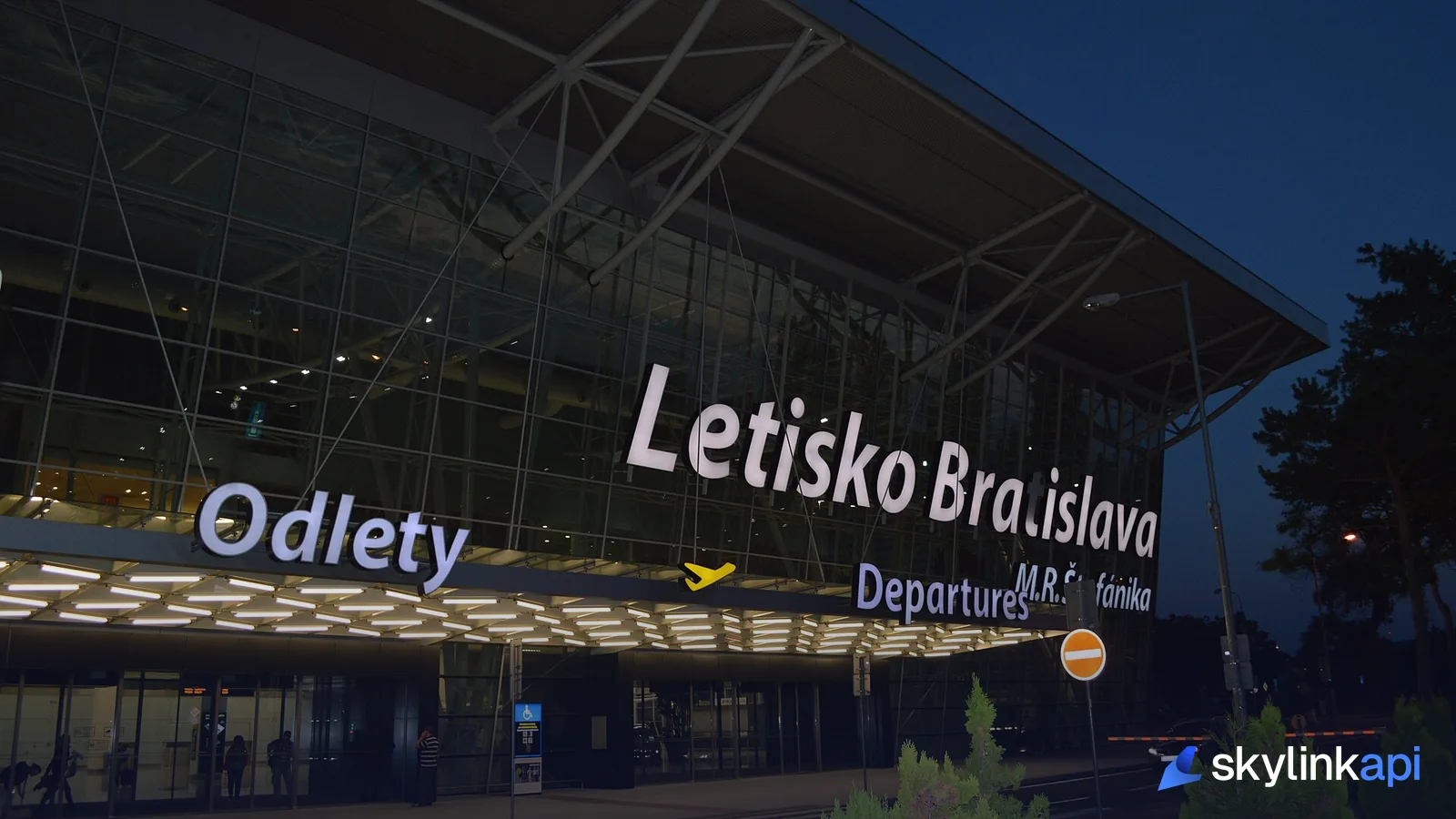 A brightly lit airport departures terminal at night
