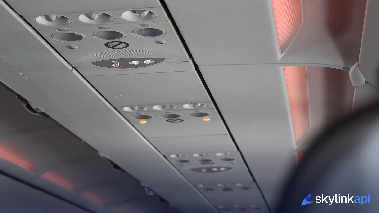 The fasten-seat-belt sign lit on an aircraft cabin's overhead panel