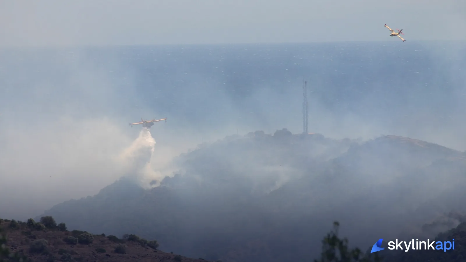 An aircraft dropping water over a wildfire, the kind of hazard that triggers a firefighting TFR
